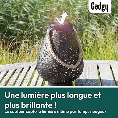 Lanterne solaire marocaine Gadgy éclairant un jardin avec des motifs orientaux.